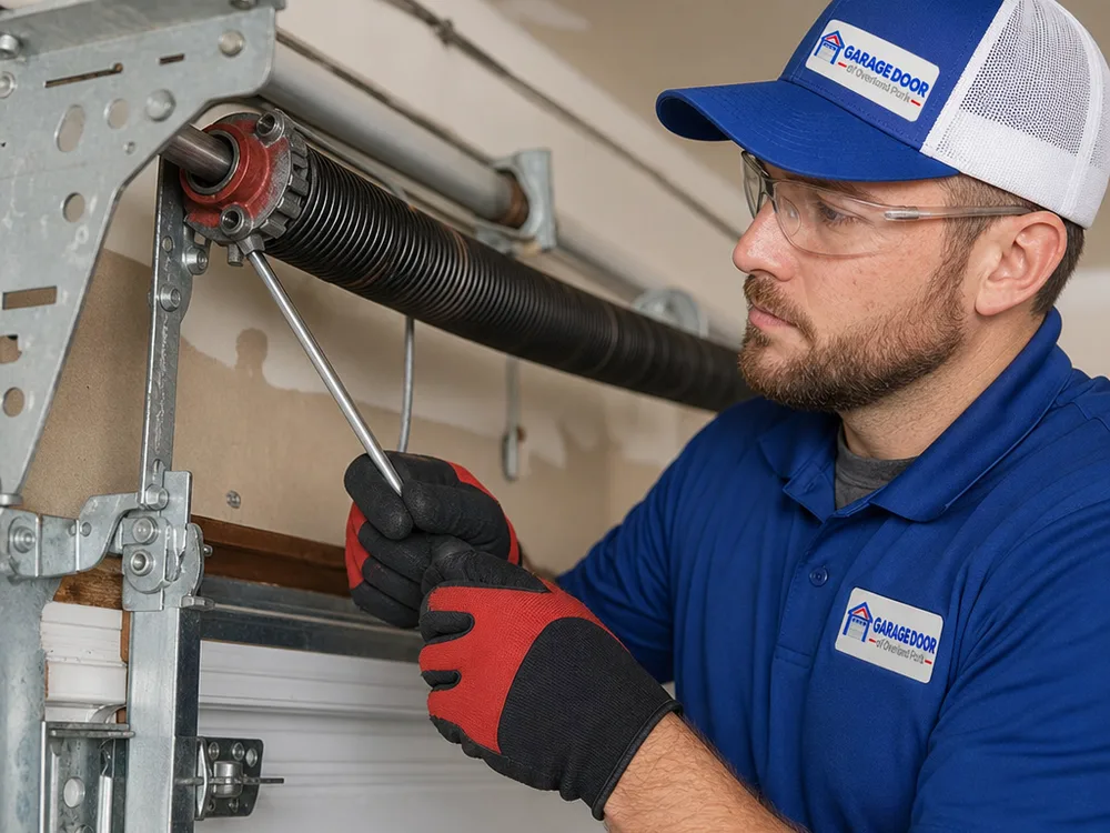 Torsion spring assembly, winding cones, center bearing plate, and lift cables being inspected above a garage door